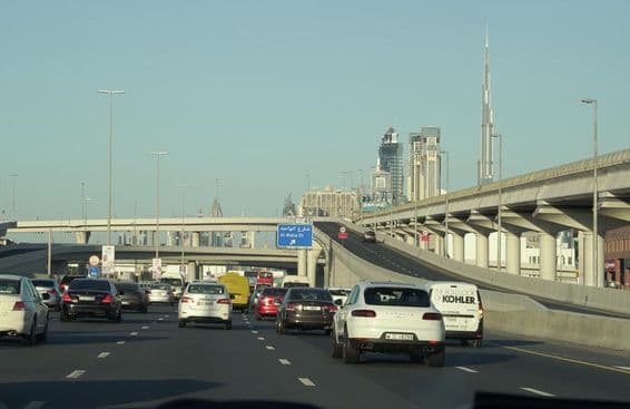 دبئی کی مشہور اسکائی اسکریپرز کے پس منظر میں رش کے دوران ٹریفک جام۔