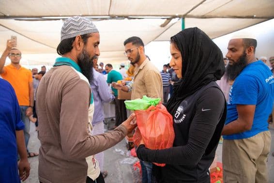 رضاکار کارکنوں کو افطار کھانے کے دوران خوراک کے پیکج تقسیم کر رہے ہیں۔