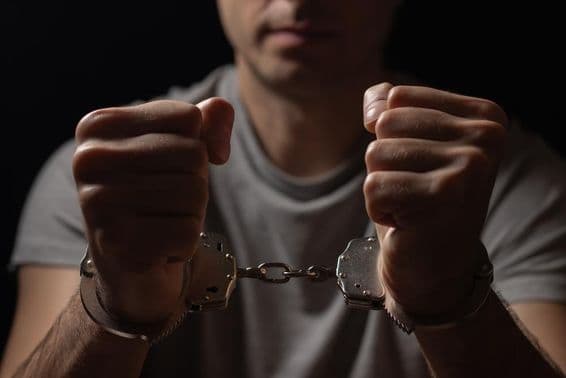 ہاتھوں میں ہتھکڑیاں پہنی ہوئی ہیں۔