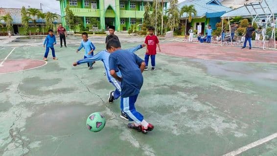 پرائمری اسکول کے طلباء ساکر کھیلتے ہوئے